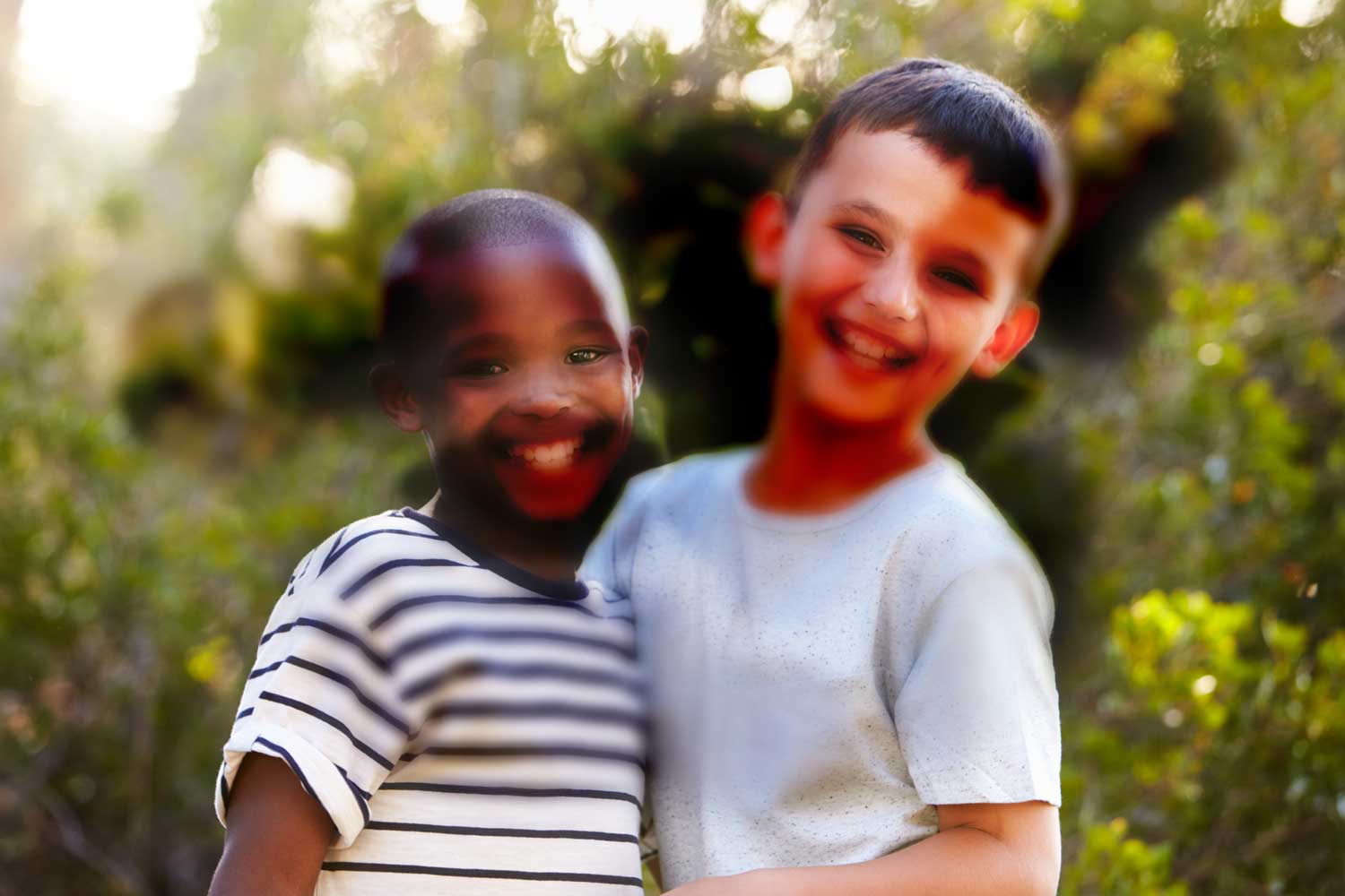 dos niños sonríen frente a la cámara. hay varias manchas negras, lo que impide la visión normal. representa la visión con enfermedad diabética del ojo.