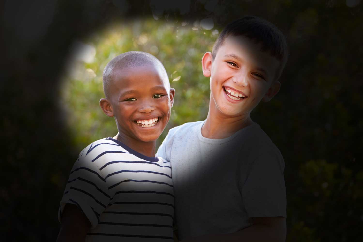 dos niños sonríen frente a la cámara. los lados de la foto se ven oscuras, lo que impide la visión normal. representa la visión con glaucoma.