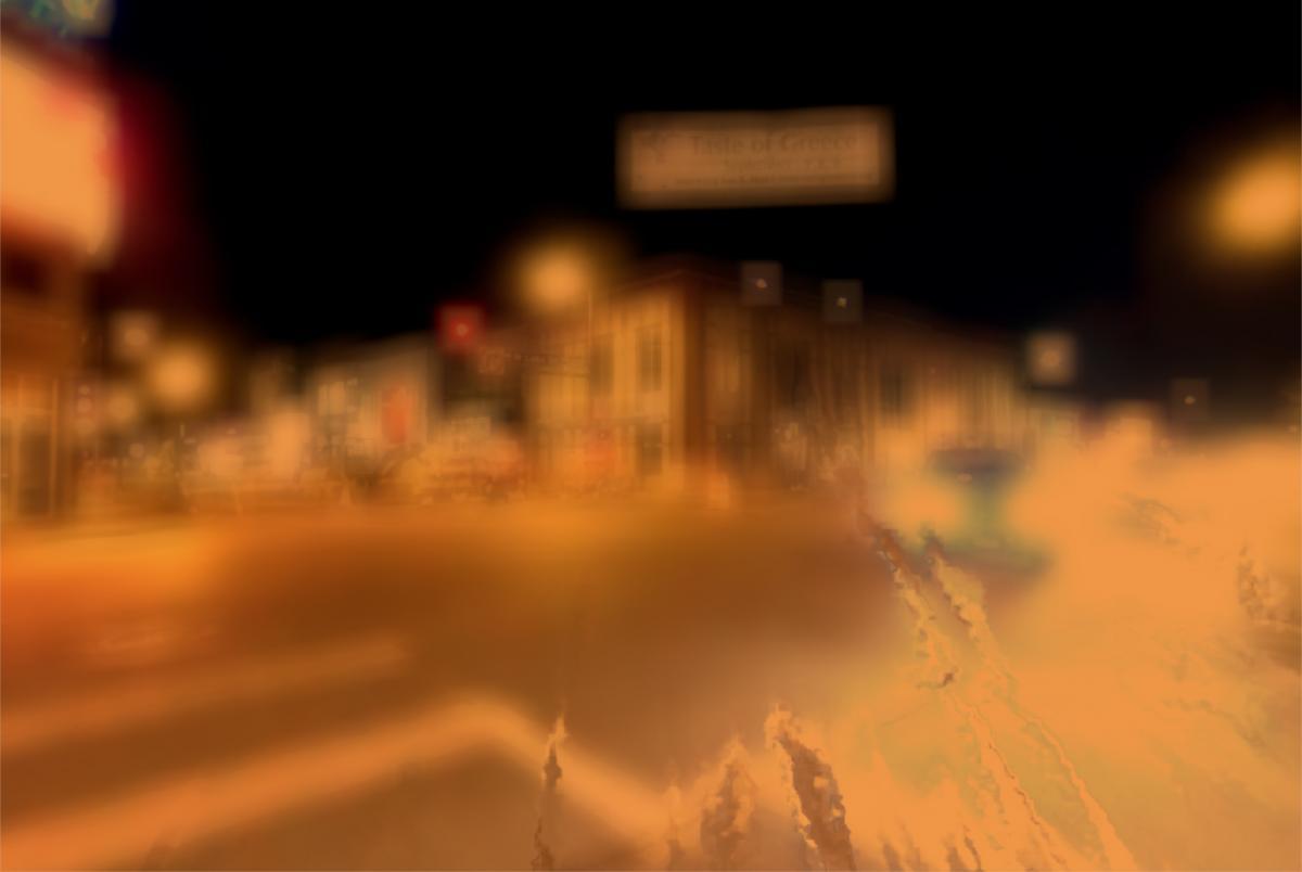 city street at night as seen by a person with cataracts; view is blurry and brown tinged
